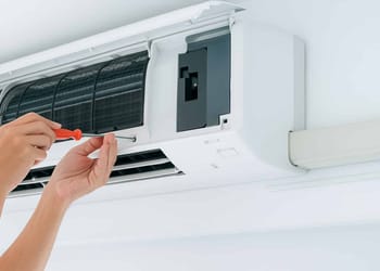 Técnico instalando aire acondicionado moderno en un hogar.