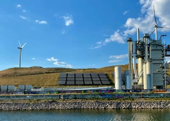 Paneles solares y molinos de viento interconectados digitalmente con nodos de datos en un atardecer