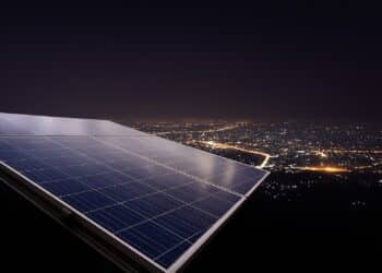 Paneles solares de noche con batería iluminando una vivienda
