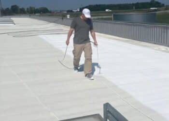 persona pintando una azotea con pintura blanca reflectante