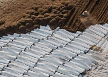 Palas eólicas retiradas apiladas para su reciclaje en una planta industrial