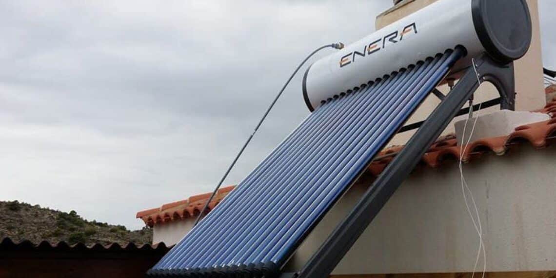 Instalador colocando un termosifón solar compacto en un tejado mediterráneo
