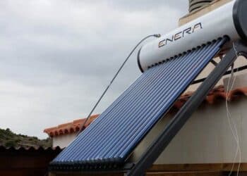 Instalador colocando un termosifón solar compacto en un tejado mediterráneo