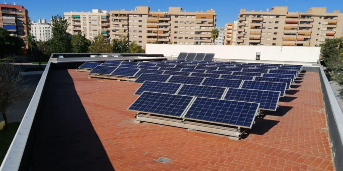 Vecinos instalando placas solares en la azotea de su comunidad
