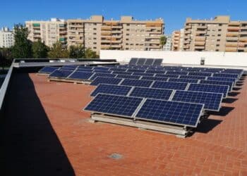 Vecinos instalando placas solares en la azotea de su comunidad