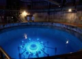 Cherenkov radiation glow from spent fuel pool in nuclear reactor, reflecting cobalt-blue light.
