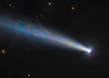 Un cometa llegado de otra estrella transporta un tipo de agua nunca visto en nuestro sistema solar 8 Cometa interestelar brillando en el espacio profundo con un núcleo luminoso y cola azul-blanca.