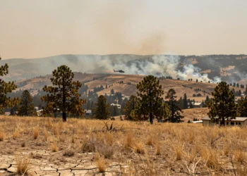 Colorado se prepara para un verano de incendios extremos, pero compartir recursos con estados vecinos será más difícil que nunca 10 Paisaje montañoso de Colorado con tierra agrietada, hierba seca y humo de incendios forestales en el cielo