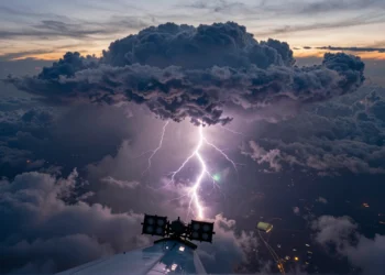 Detectores de rayos gamma dentro de tormentas revelan que los relámpagos podrían nacer de procesos vinculados a supernovas y agujeros negros 10 Vista aérea de una tormenta tropical mostrando relámpagos y destellos gamma en el cielo.