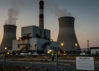 Trabajador solitario frente a una enorme central eléctrica de carbón en ruinas en Virginia Occidental al atardecer