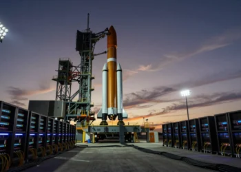 Cohete SpaceX Falcon 9 en la plataforma de lanzamiento al atardecer junto a servidores y cables de fibra óptica