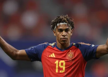 Lamine Yamal con la camiseta roja de España número 19, brazos abiertos, gesto sereno tras un partido del Mundial