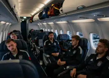 Jugadores de fútbol agotados en un avión comercial durante un largo viaje transcontinental antes del Mundial