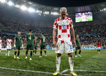 Luka Modrić solo en el césped tras el pitido final, cabizbajo con la camiseta a cuadros de Croacia