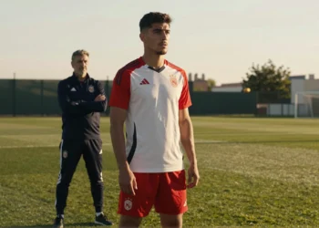 Julián Álvarez en el entrenamiento del Atlético de Madrid con Simeone observando al fondo bajo la luz dorada del atardecer