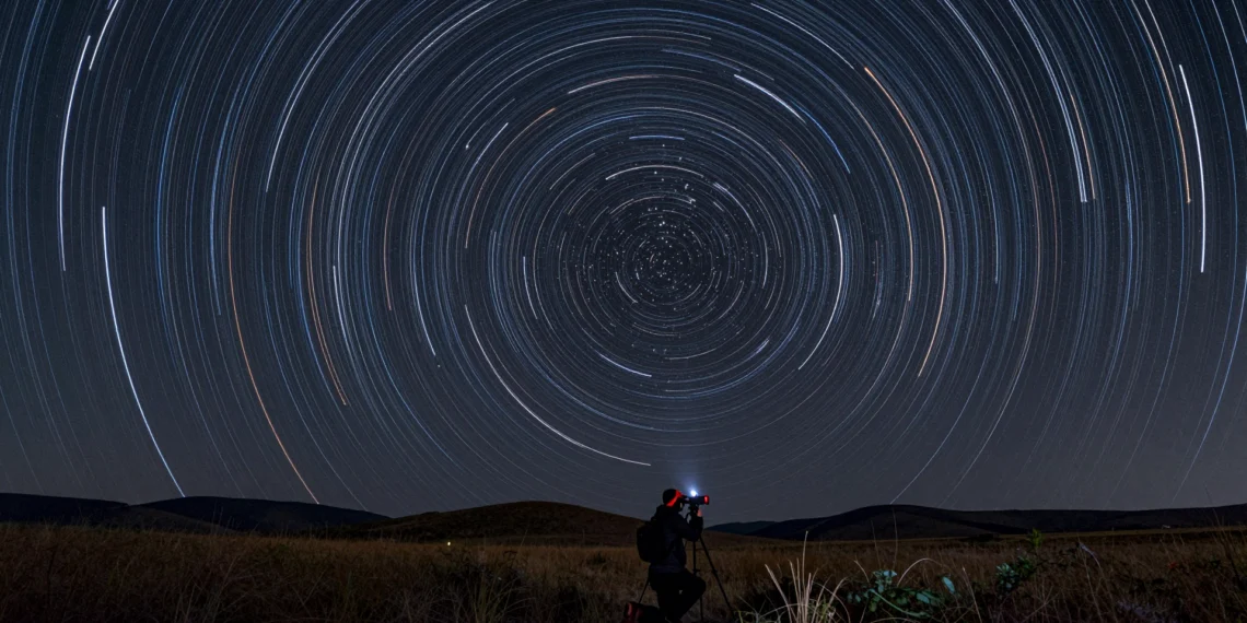 Cada noche el cielo dibuja arcos de luz sobre tu cabeza, y una cámara puede capturarlos todos 1 Fotógrafo capturando trazos de estrellas en exposición larga con arcos de luz alrededor de la Estrella Polar