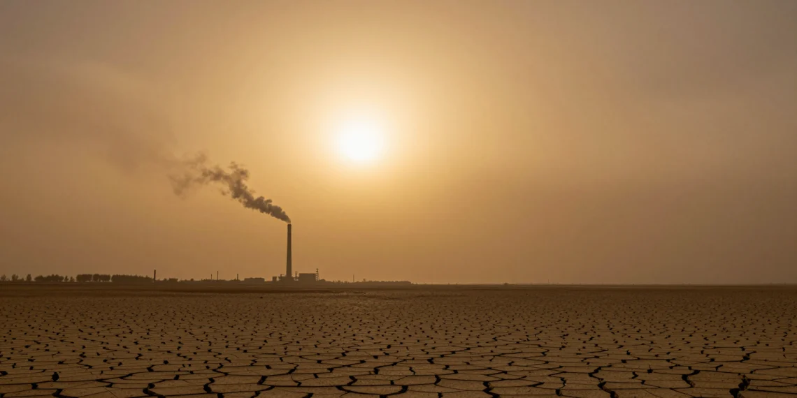 Tres años seguidos por encima de 1,5 ºC: el planeta acaba de cruzar un umbral climático que nadie había visto antes 1 Paisaje árido y reseco bajo un cielo cargado de smog con tonos ámbar, tierra agrietada y chimenea industrial en el horizonte
