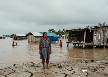 Décadas de emisiones acumuladas, millones de desplazados sin protección: la brecha que la justicia climática aún no ha cerrado 7 Mujer indígena desplazada frente a un pueblo costero inundado en una nación tropical empobrecida por el cambio climático