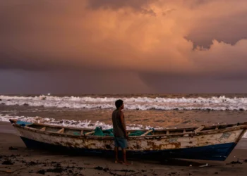 De anomalía costera a fenómeno global: El Niño lleva siglos transformando el clima del planeta y cada vez lo hace con más fuerza 1 Pescador peruano junto a su barca varada en la costa del Pacífico, con aguas cálidas y cielo tormentoso por El Niño
