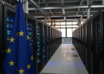 Europa construye su futuro en IA sobre chips que no puede fabricar, y su nueva ley de semiconductores podría profundizar esa dependencia 1 Gran sala de centro de datos europeo con hileras de servidores GPU iluminados en azul y la bandera de la UE en primer plano